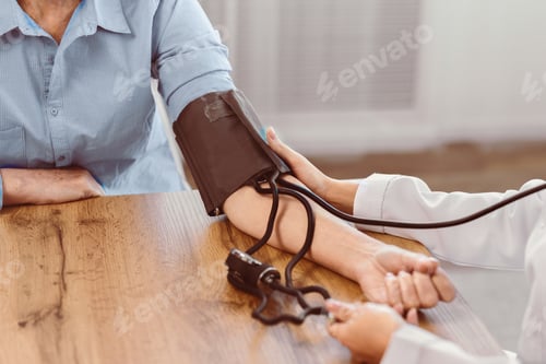 Preview: Female doctor checking blood pressure of old man