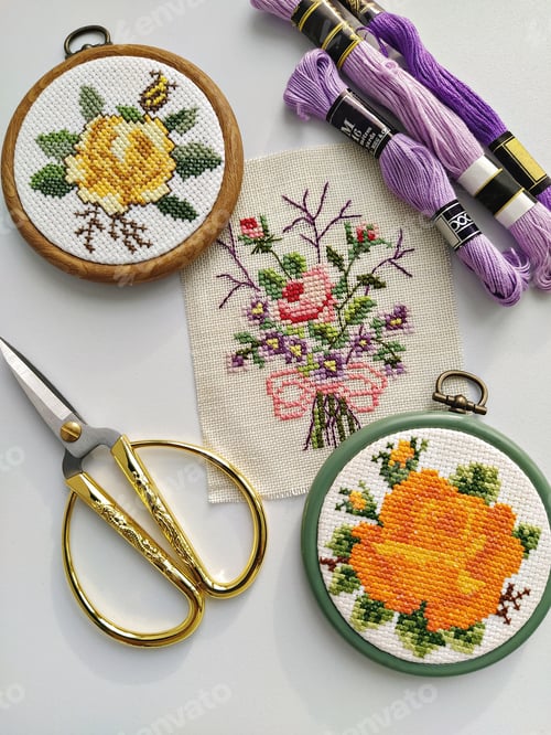 Preview: Vintage wooden embroidery hoops, scissors, needle, thread and fabric with floral cross-stitch embroi