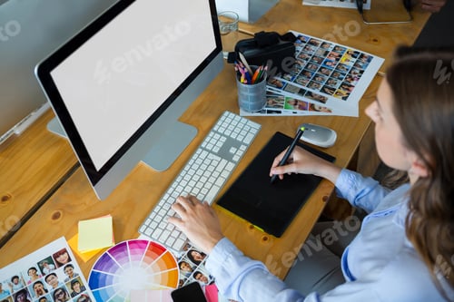 Preview: Female graphic designer using graphics tablet at desk
