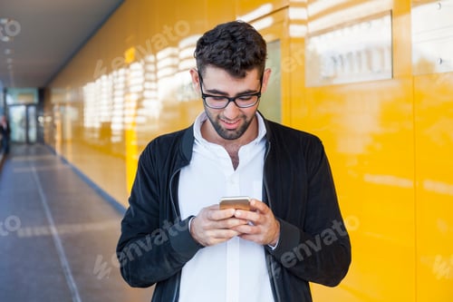Visualização: Jovem empresário sorridente usando telefone celular