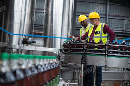 Preview: Factory workers monitoring cold drink bottles at drinks production plant