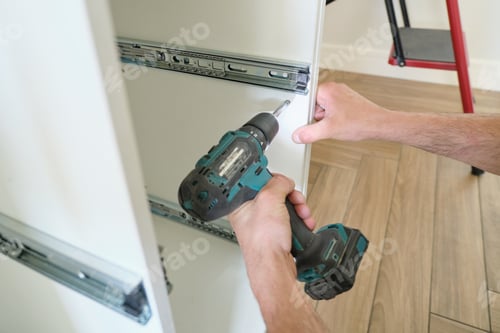 Preview: Closeup of hand worker doing furniture, assembling kitchen with professional tools