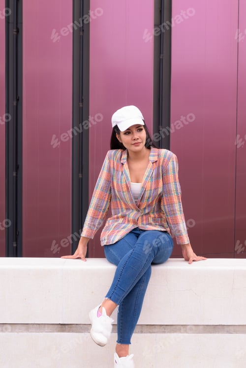 Preview: Portrait of young beautiful Asian woman sitting outdoors