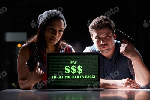 Preview: Shot of two armed hackers using a laptop with Pay $$$ to get your files back on it