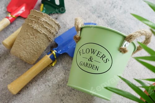 Preview: Gardening tools and flower pots with plants on a table