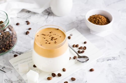 Preview: Dalgona coffee - Korean trendy drink - in a glass on the table. Social media drink.