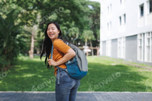 Preview: Happy university student smiling and walking on campus