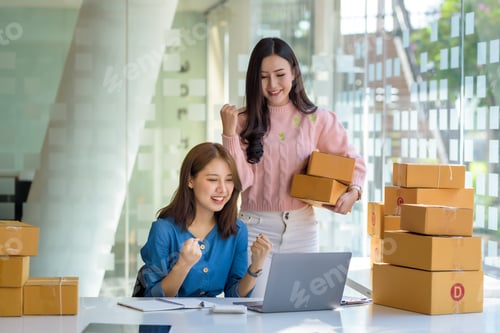 Preview: Two beautiful young Asian business owner woman prepare parcel box and check online orders