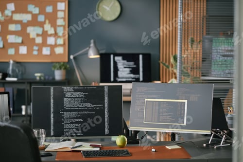 Preview: Modern Office Workspace Featuring Computer Monitors Displaying Programming Code