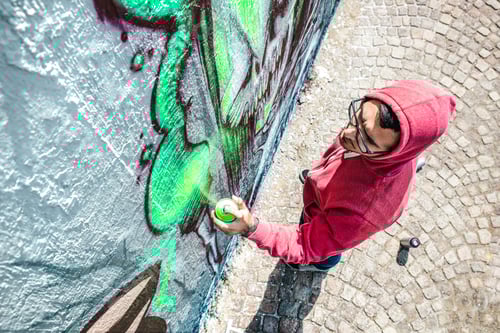 Visualização: Vista superior de artista de rua pintando grafite em parede genérica