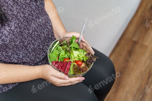Preview: Woman Holds Fresh Salad Bowl on her Lap