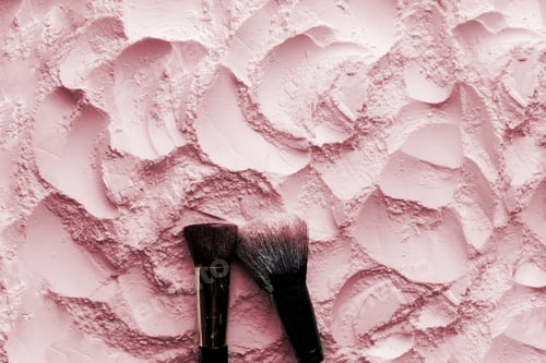 Preview: Makeup brushes on pink cosmetic powder background. Flat lay, top view.
