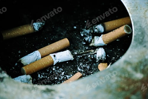 Preview: Crowd of used butts or cigarettes in a dirty, old, and rusty ashtray