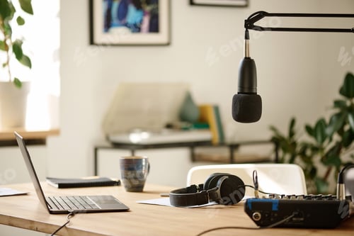 Preview: Microphone hanging over desk with headphones, soundboard and laptop