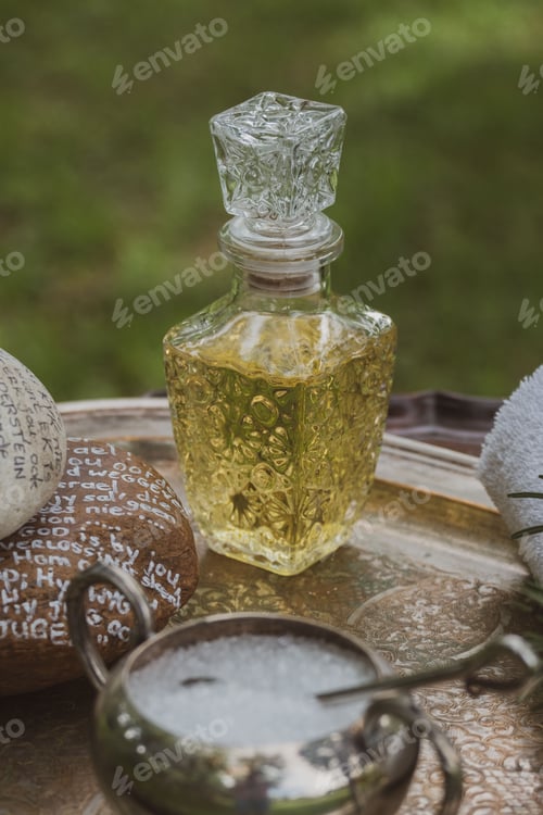 Preview: Vertical shot of essential oil in vintage glass perfume bottle and bubble liquid on metal tray