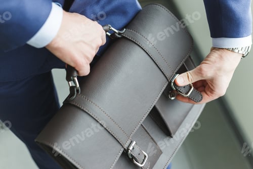 Preview: Man in suit fastens briefcase. New vacancy for the position