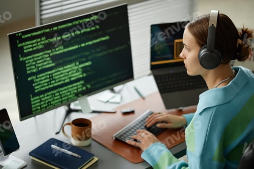 Preview: Young Woman Writing Computer Code on Desktop Computer at Workplace