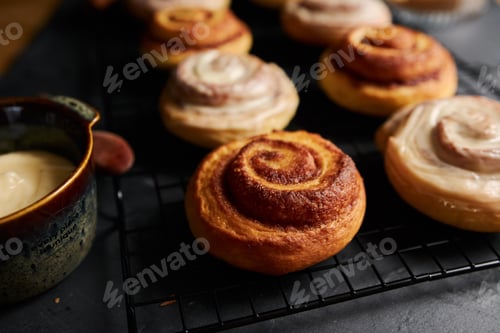 Preview: Selective focus shot of delicious Cinnamon Rolls with White Glaze on a black table