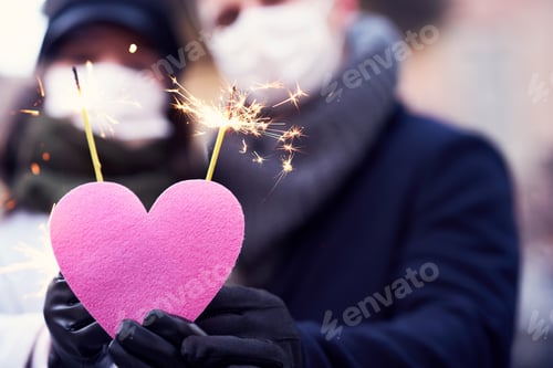 Preview: Happy couple celebrating Valentines Day in masks during covid-19 pandemic