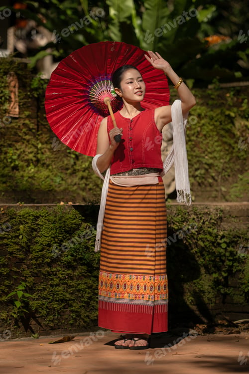 Preview: Asian woman wearing traditional Thai dress holding a red umbrella