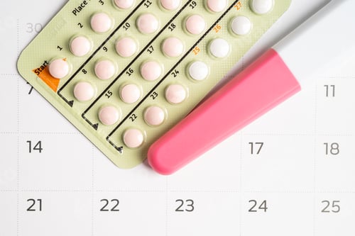 Preview: Pregnancy test and birth control pills on calendar, contraception health and medicine.