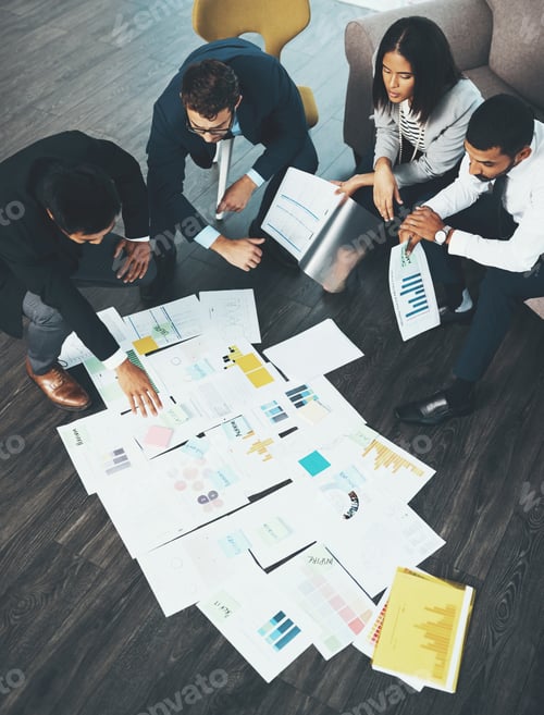 Preview: Shot of businesspeople having a brainstorming session with documents spread out in front of them