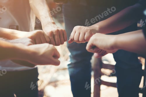 Preview: Close up of young people putting their hands together. Team with stack of hands showing unity.