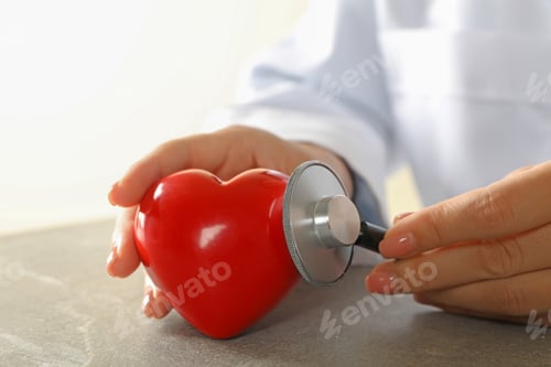 Preview: Female doctor with stethoscope checking heart beat