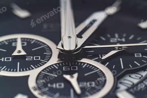 Preview: Closeup shot of the hands, numbers and hour marks of a black watch