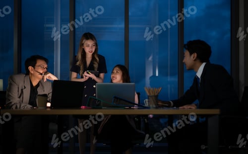 Preview: Group of business people working in office at night. Business concept.