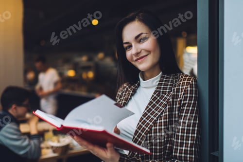 Preview: Cheerful woman with notebook in cafe