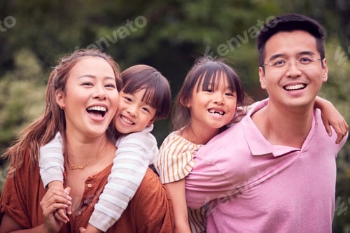 Vista previa: Portrait Of Smiling Asian Family Outdoors With Parents Giving Children Piggybacks