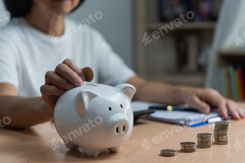 Preview: woman putting coin into piggy bank and saving money for future plan and retirement fund earning mone