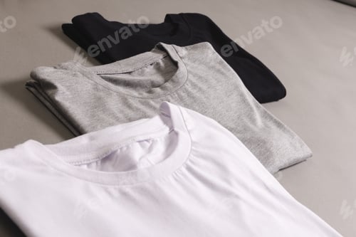 Preview: Three t shirts with copy space on grey floor background
