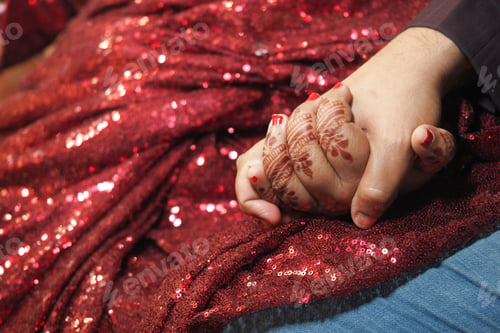 Preview: Couples holding hands adorned with henna in festive attire