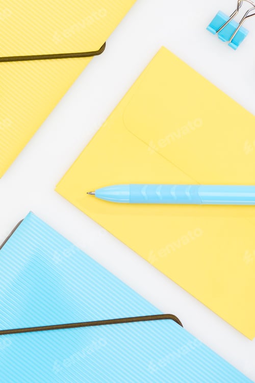 Preview: yellow and blue folders, envelope paper clip and pen isolated on white