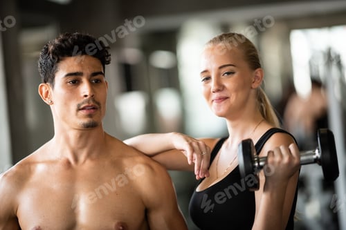 Visualização: Personal trainer ajudando mulher a se exercitar na academia esportiva