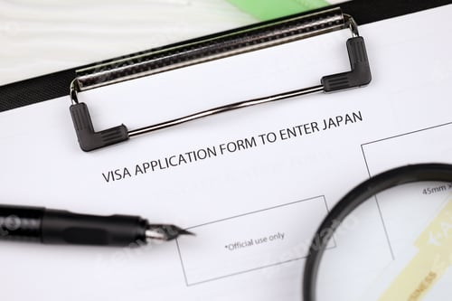 Preview: Visa application to enter Japan on A4 tablet lies on office table with pen and magnifying glass
