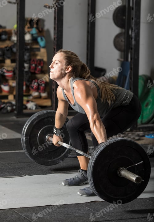 Preview: Strong young female weight lifter doing heavy deadlift.