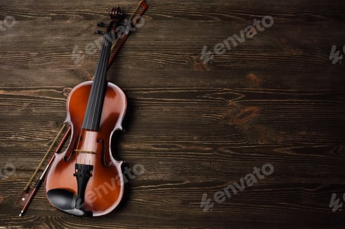 Preview: Violin with bow on brown wooden table.