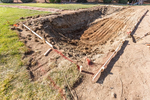 Preview: Freshly Dug Hole In Yard Preparing For Swimming Pool Installation