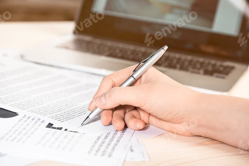 Preview: cropped view of businesswoman signing contract documents sitting at table