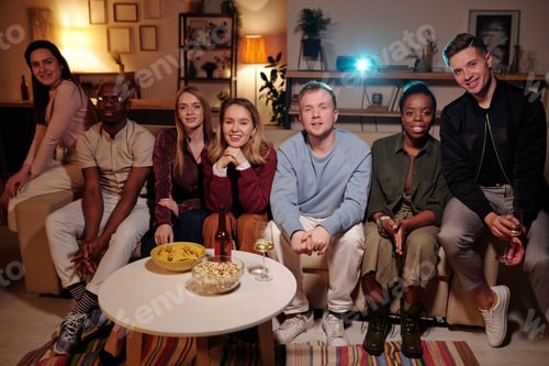 Preview: Intercultural friends relaxing on couch and watching interesting movie together