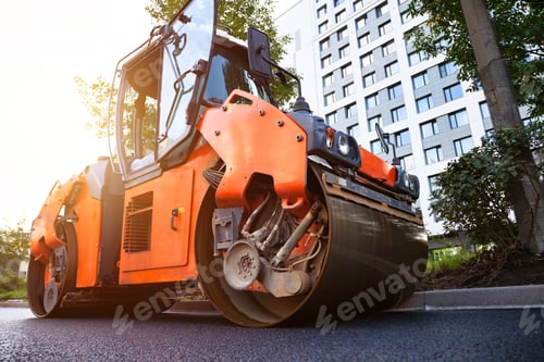 Preview: Orange Road Roller Compacting New Asphalt on a City Street