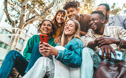 Preview: Happy young people using smart mobile phone device outdoors