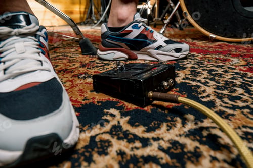 Preview: man's foot pressing bass drum pedal in recording studio drummer drumming indoors closeup