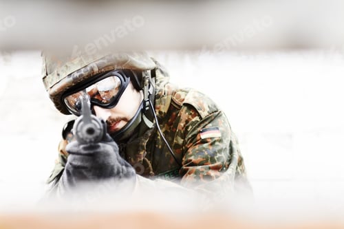 Preview: Closeup of a soldier pointing his gun at the camera through a slot in the foreground