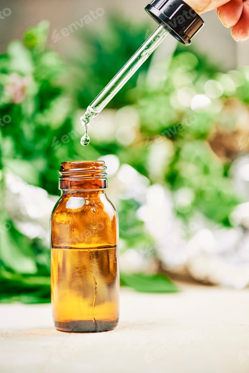 Preview: drop dispenser with cbd essential oils, drop falling into bottle filled with oil