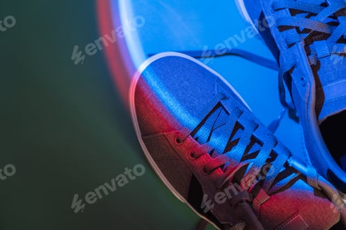 Preview: Fabric sneakers with rubber white sole on a green background under blue light