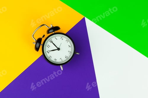 Preview: Black alarm clock on color block background, office interior